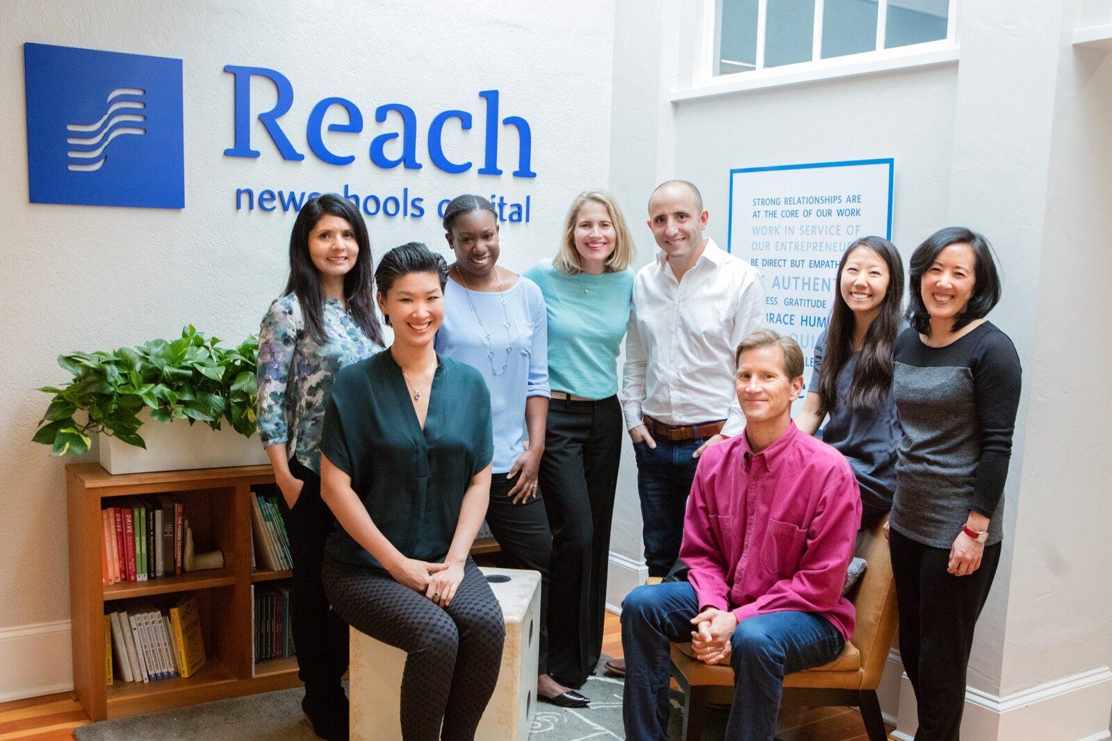 A group of people in front of a Reach Capital logo
